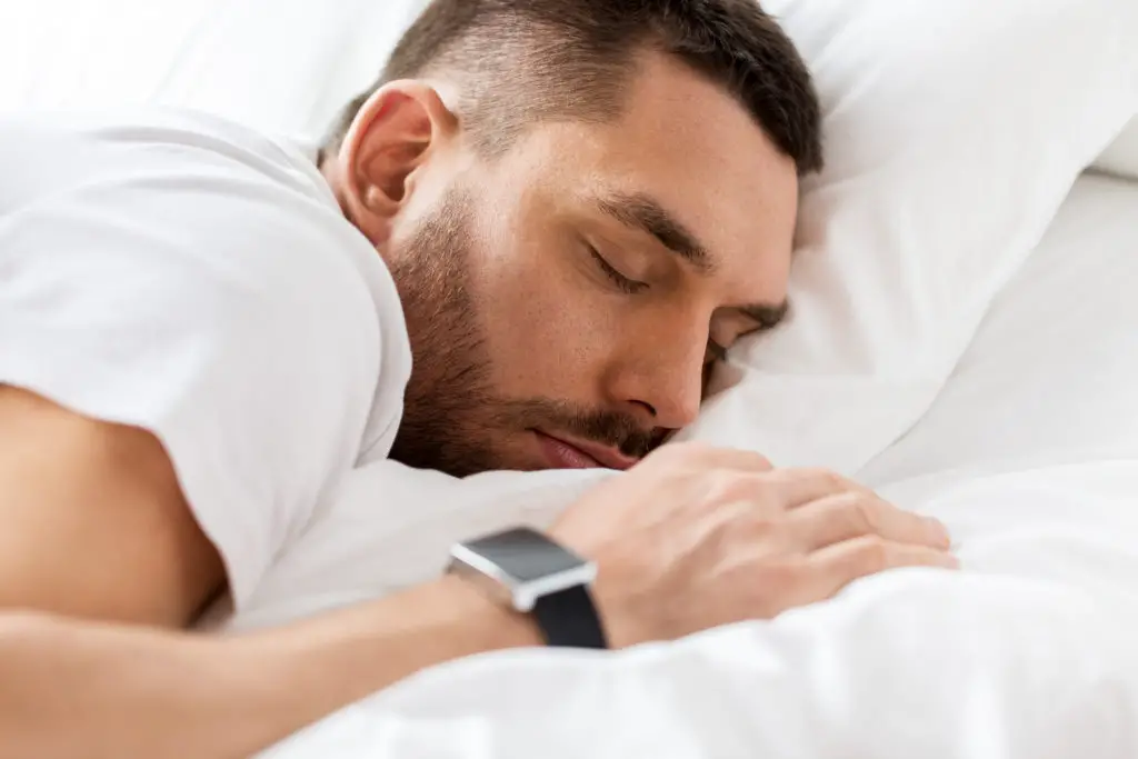 Homme dort avec bracelet connecté